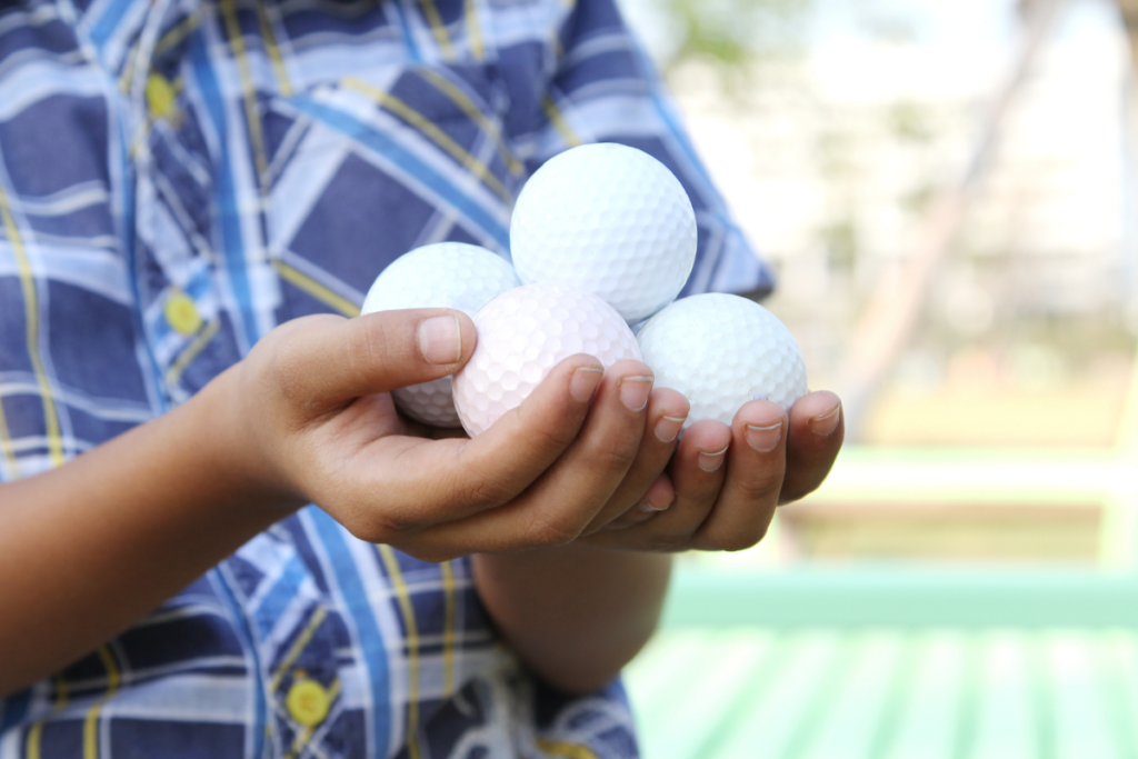 boy holding golf balls