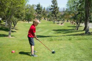 junior golfer driving the ball