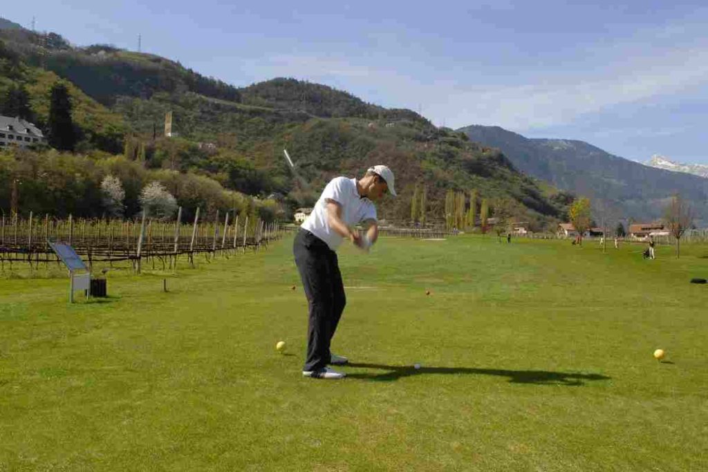 Golfer taking the club back during a swing