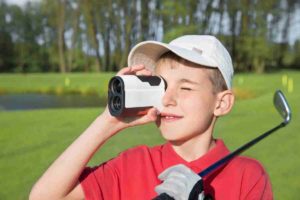 junior golfer using rangefinder on the golf course