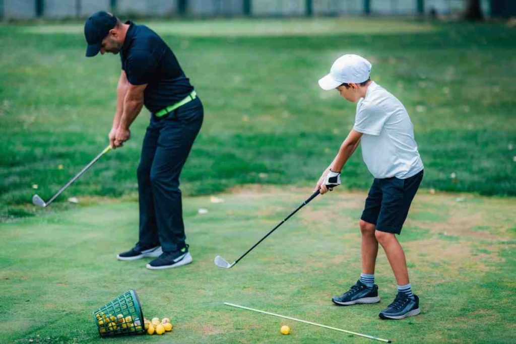junior golfer practing swing with alignment sticks