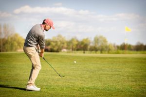golfer pitching with a pitching wedge