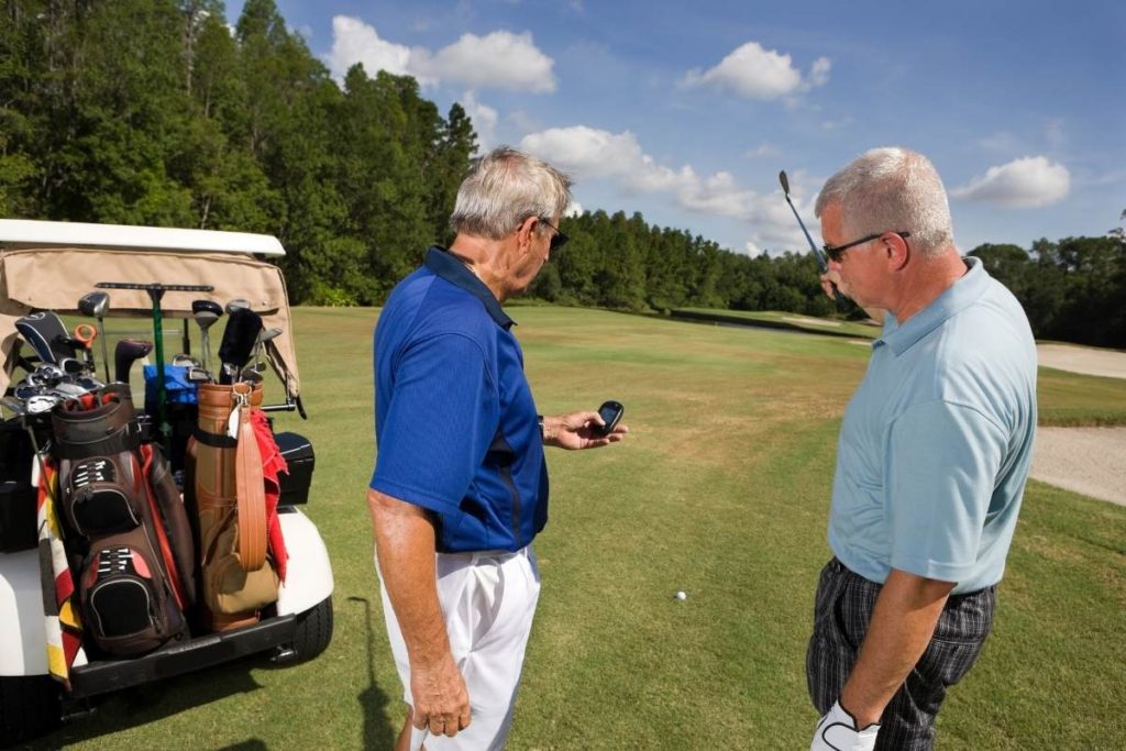 golfers looking at handheld golf gps device