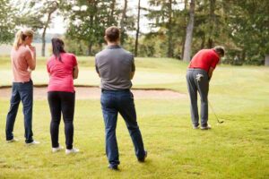 group of golfer watching one player
