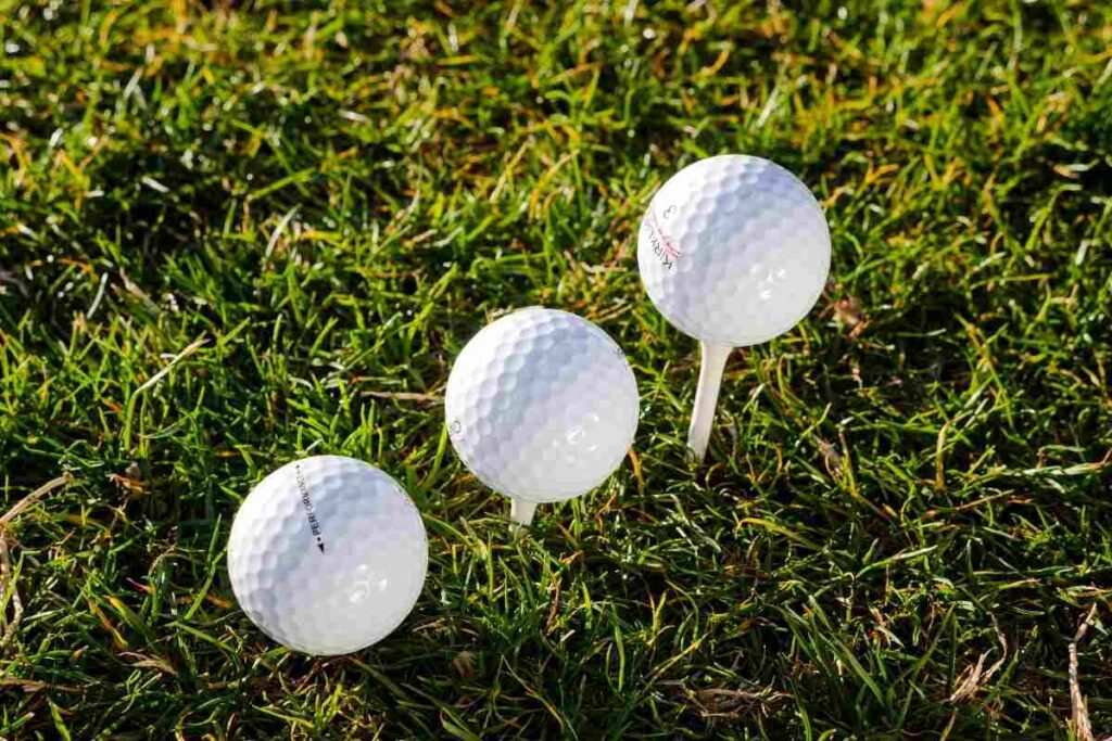 three golf balls teed up