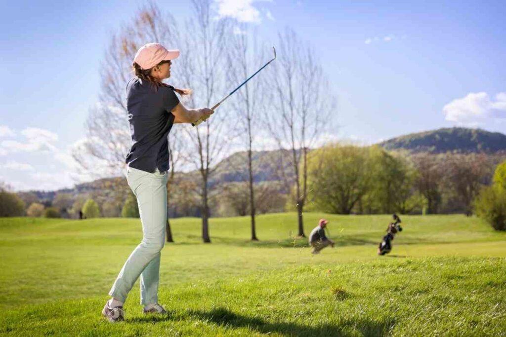 female golfer hitting approach wedge