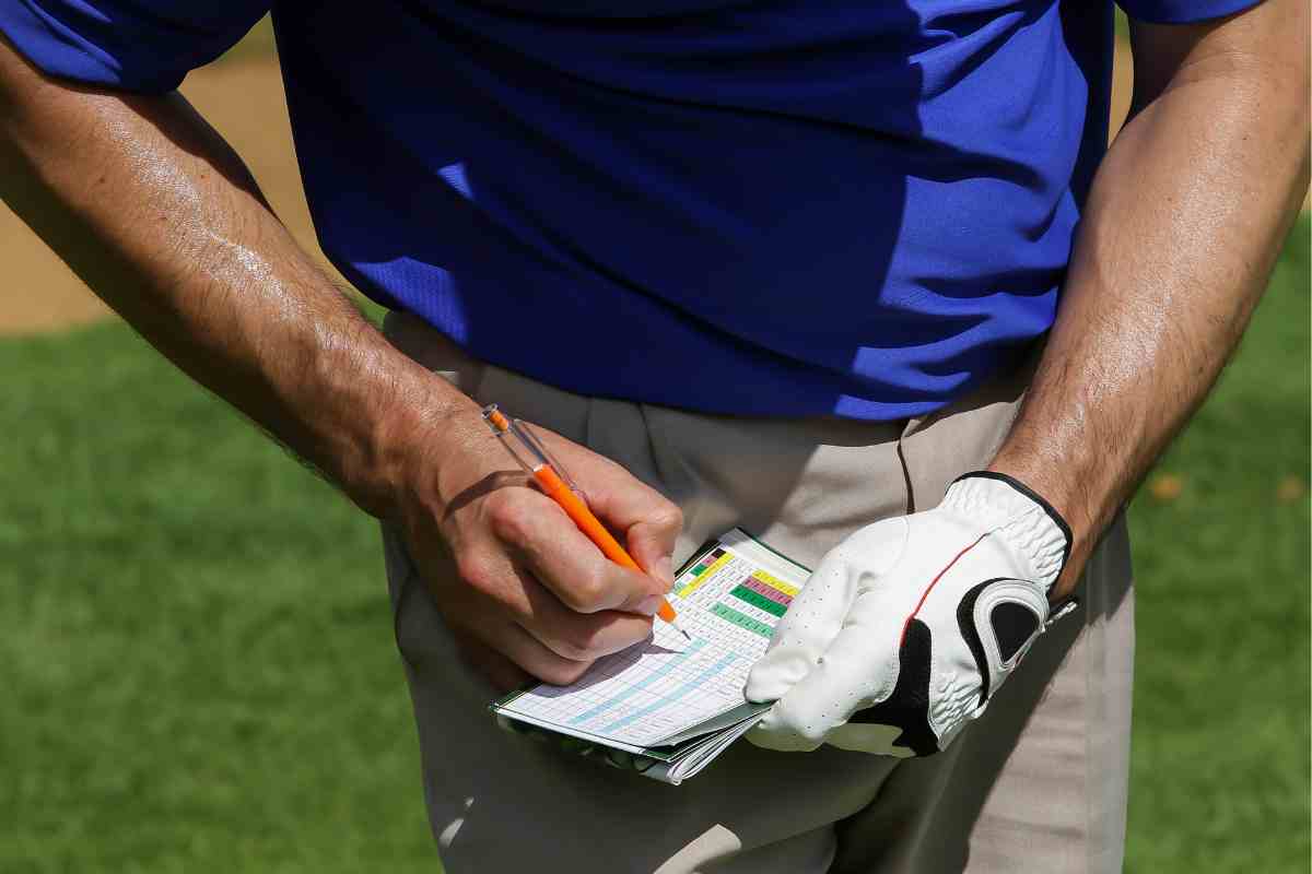 golfer keeping score on scorecard