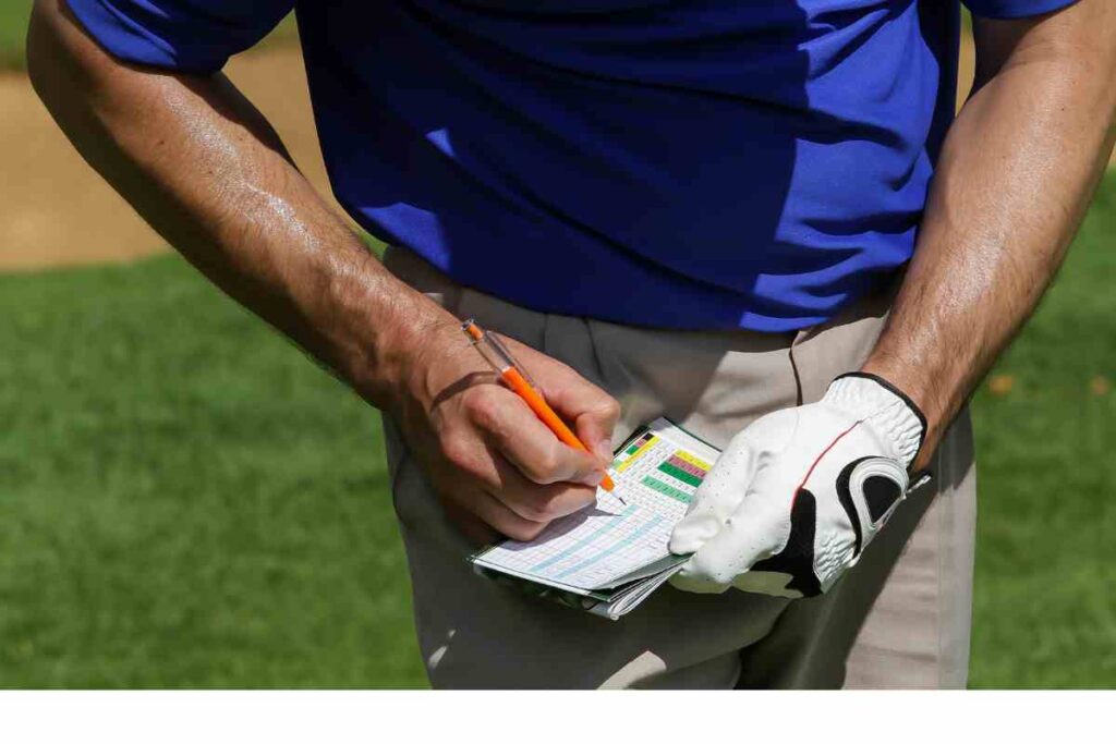 golfer marking down score on scorecard